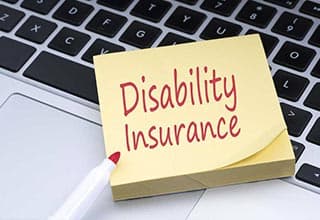 disability insurance sticky note reminder on laptop computer