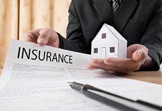 insurance employee holding house and insurance contract